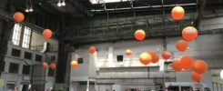 Beispielfoto einer Messehalle mit Menschen und Luftballons